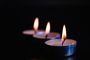 The flame of many candles burning in the background