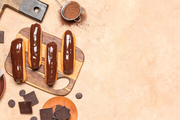Composition with wooden board with tasty eclairs, chocolate and cocoa powder on color background