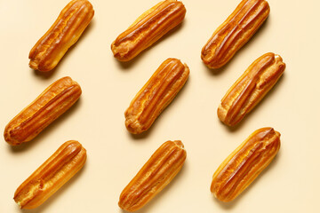 Tasty sweet eclairs on color background