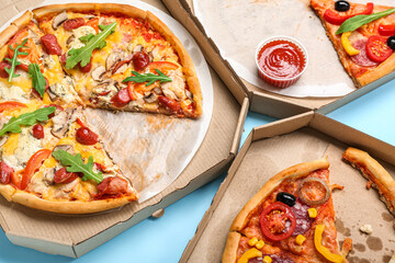 Cardboard boxes with tasty pizza on color background, closeup