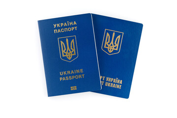 Two Ukrainian passports lie on top of each other, isolated on white background. Inscription in Ukrainian Ukraine Passport.