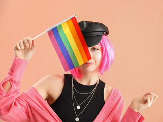 Young woman with LGBT flag on pink background, closeup