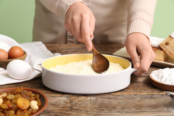 Woman preparing cheese pie on wooden table