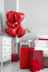Interior of bedroom decorated for Valentine's Day with balloons and shopping bags