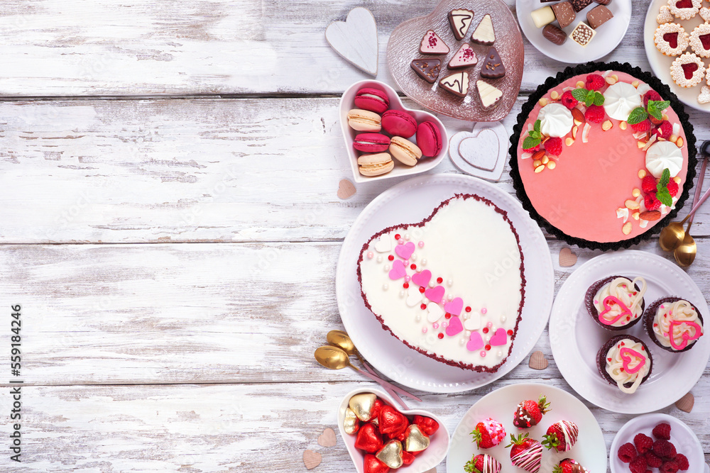Poster valentines day side border with a selection of desserts and sweets. top down view over a white wood 