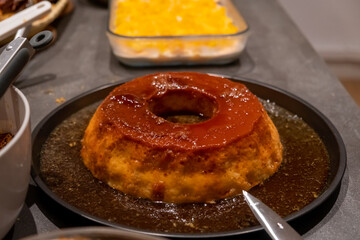 Traditional Brazilian desserts pave and pudim served at a Decorated New Year's table with golden...