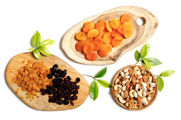 Dried fruits and nuts mixed and branches with young leaves on white background. Concept of the Jewish holiday Tu Bishvat