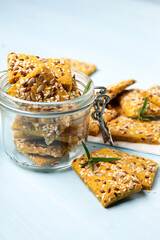 Gluten free Homemade Crackers and Rosemary for Appetizer on Blue Wooden Background.