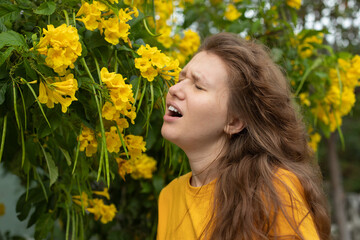 Portrait of beautiful young allergic woman is suffering from pollen allergy or cold on natural...