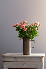 Bouquet of roses in a vase on a table, light background