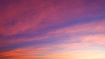 Naklejka na ściany i meble Beautiful romantic orange sunset clouds with yellow sunlight on dusk sky twilight background