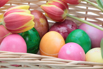 Basket with colorful Easter eggs on white background