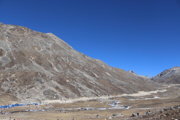 Mountain, ice, sun bund, blue sky, water, cloudy, cool weather, green tree, flower, fog, black stone View of Zero Point, Yumthang, Sikkim, india.