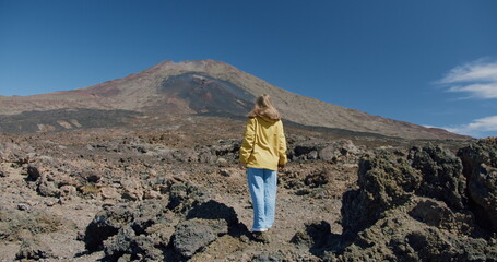 Naklejka premium Traveler looking at volcanic rocky mountain landscape. Teide Nation Park, Spain.