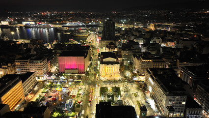 Aerial drone night shot of famous neoclassic Municipal Theatre of Piraeus and recently renovated main square illuminated during Christmas period, Attica, Greece