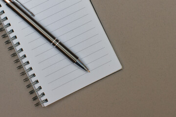 A notebook with a blank page and a pen resting on it