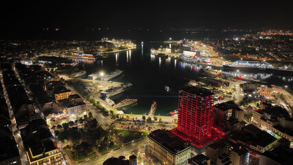 Aerial drone night shot of illuminated tower and port of Piraeus during New Year's eve celebrations, Attica, Greece