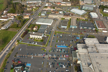 Aerial view of many colorful cars parked on parking lot with lines and markings for parking places and directions