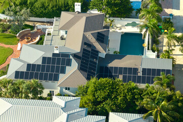 Big new residential house in USA with rooftop covered with solar photovoltaic panels for producing...
