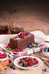 Chocolate sponge cake with fresh fruit on white dish.