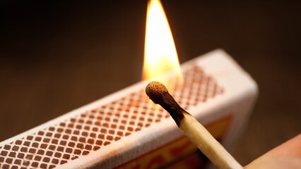 match is lit from a matchbox. Close-up of a wooden match