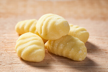 Close-up of raw potato POTATO GNOCCHI on a cutting board. Macro shot from low angle view. Focus stacking.