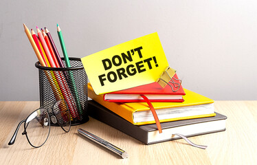 DON'T FORGET written on a sticky on notebooks
