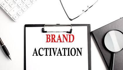 BRAND ACTIVATION text written on paper clipboard with office tools