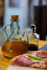 a decanter with olive oil stands on a table in a cafe or pizzeria.