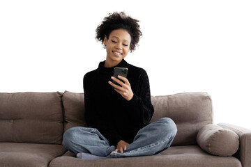 The curly-haired woman smiles uses the phone writes sms makes an online order sits on the couch, transparent background.