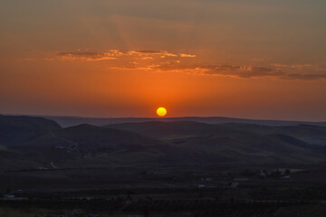 Sunrise view of mount nemrut, the sun cames up from east behind the mountains and lake and colorful clouds make the view better