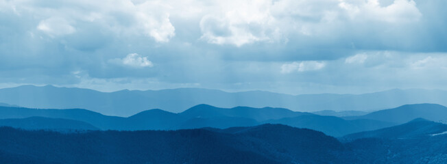 Beautiful nature panorama of dark blue mountain landscape. Horizontal image.