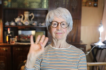 Senior woman saluting with hand gesture 