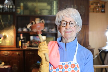 Senior woman holding a plunger  