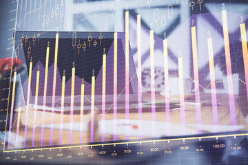 Stock market graph on background with desk and personal computer. Multi exposure. Concept of financial analysis.