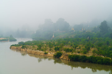 Fototapeta premium River and Pagoda in misty landscape, Moei River, Tha song yang District, Tak Province, Thailand.