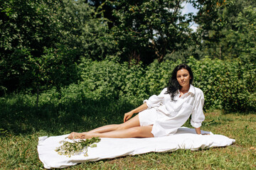  Happy Young Woman Sitting in the Grass Enjoining Nature. Carefree person resting in a countryside field experiencing mindfulness and calmness - 559213066