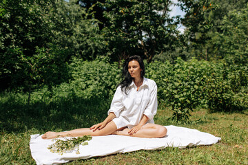  Happy Young Woman Sitting in the Grass Enjoining Nature. Carefree person resting in a countryside field experiencing mindfulness and calmness - 559213090