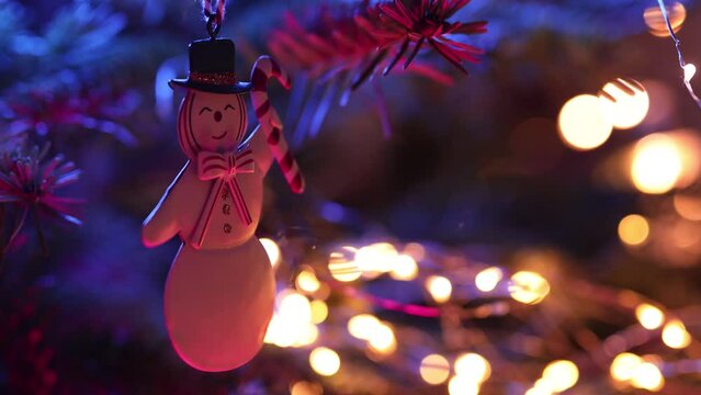 New Year's toys, decorations and garlands on the Christmas tree. Beautiful bokeh and light reflections.