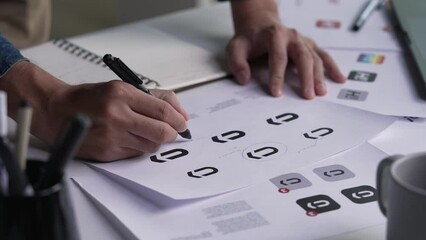 Graphic designer drawing sketches logo design. The concept of a new brand. Professional creative occupation with idea.