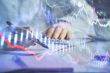Double exposure of woman's hands making notes with forex graph hologram. Concept technical analysis.