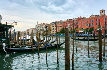 Naklejka premium Beautiful cityscape in Venice with gondolas and picturesque vintage buildings on the Grand Canal under cloudy sky in the morning.
