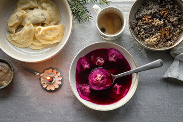 Essential Ukrainian Christmas Eve supper dishes - borsch with vushka (porcini dumplings), varenyky, kutia, uzvar on linen tablecloth.  