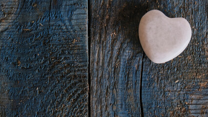 Piedra con forma de corazón sobre un fondo de madera azul rústica con copy space. Amor
