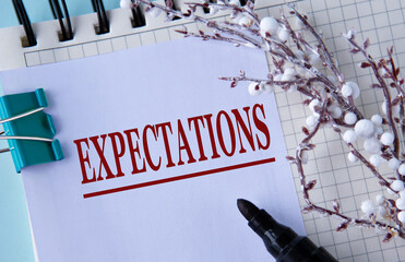 EXPECTATIONS - word on a white sheet in a notebook with a pen