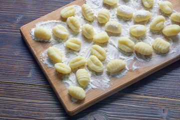 Balkan cuisine. Njoke , potato gnocchi, dumpling on wooden cutting board. Rustic background. Copy space