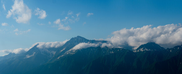 Beautiful mountain landscape, clouds over the peaks of the mountains, sunny day