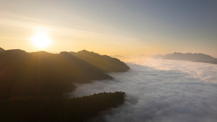 Obraz premium Amazing sun rise over mountain against white sea of clouds or mist over valley . Beautiful natural view over Salween river border between Thailand and Myanmar.Unseen KloSeLo View Point .