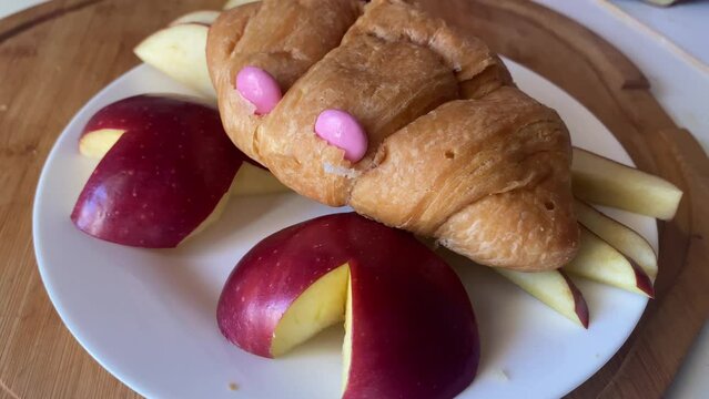 Creative kids breakfast, Croissant and apple crab. Food preparation and decoration. Close up. High quality 4k footage
