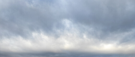 Dark gray clouds and a narrow white streak in the sky in rainy weather